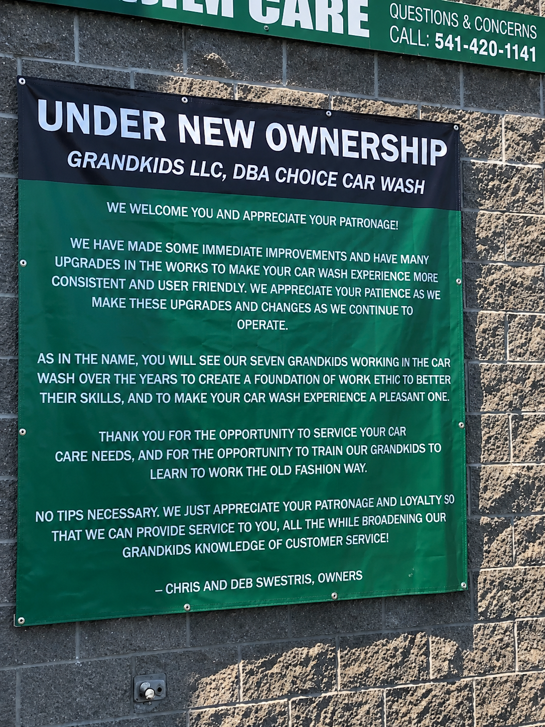 Sign on the Choice Car Wash building that reads 'Under New Ownership' with mission statement below
